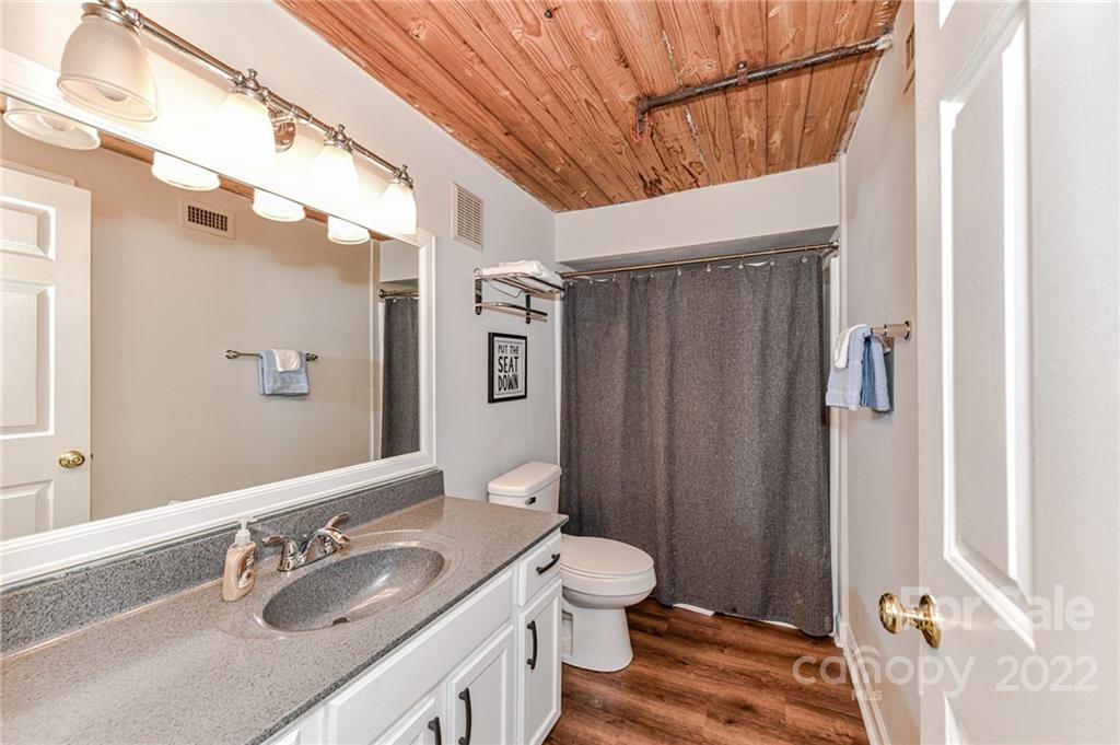 201 South Hoskins Road, Unit 106 Charlotte, NC 28208 - Photo 3 of 18 a bathroom with a granite countertop sink toilet and shower