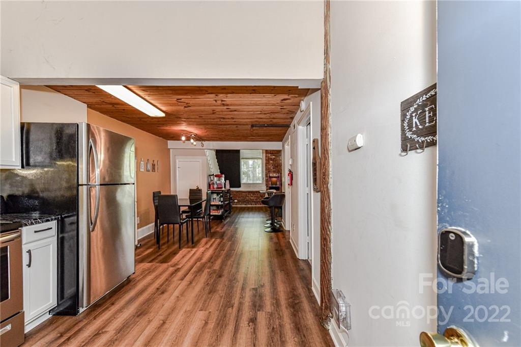 201 South Hoskins Road, Unit 106 Charlotte, NC 28208 - Photo 4 of 18 a view of a hallway with wooden floor fireplace and living room