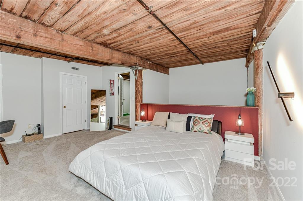 201 South Hoskins Road, Unit 106 Charlotte, NC 28208 - Photo 9 of 18 a bedroom with a bed and a chandelier