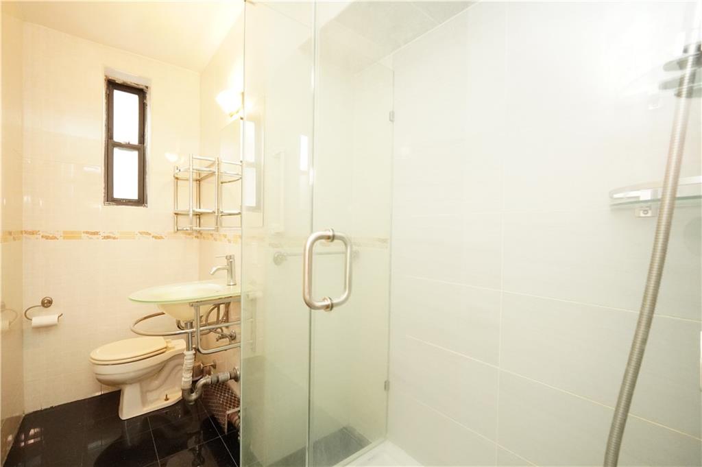 345 Webster Avenue, Unit 3N Brooklyn, NY 11230 - Photo 5 of 10 a white toilet sitting next to a bathroom sink and a shower