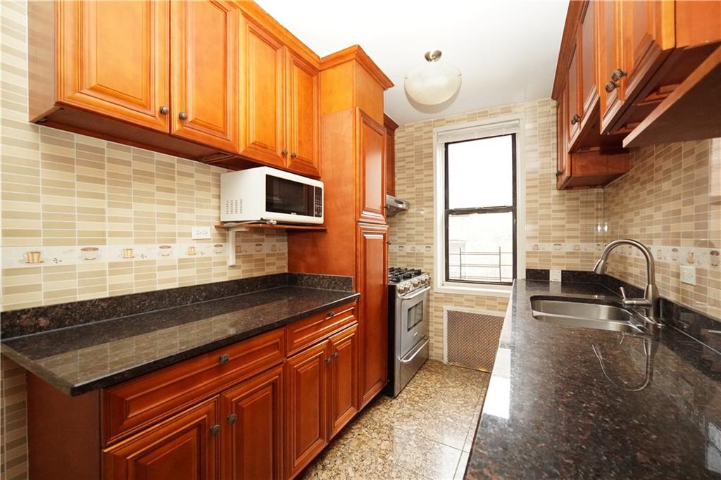 345 Webster Avenue, Unit 3N Brooklyn, NY 11230 - Photo 6 of 10 a kitchen with stainless steel appliances granite countertop a stove a sink and a microwave
