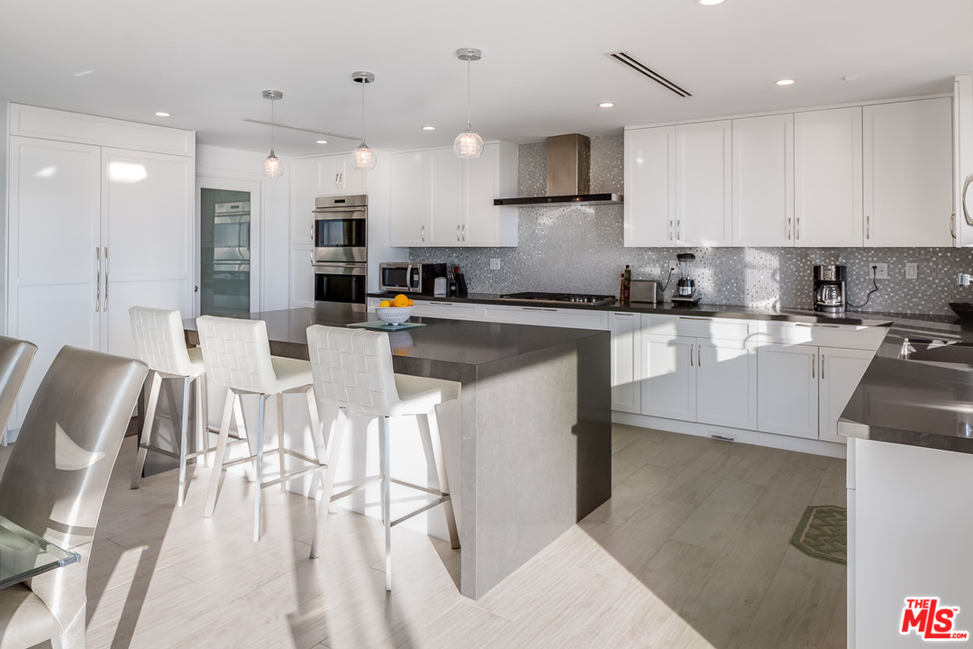 31528 Broad Beach Road Malibu, CA 90265 - Photo 15 of 26 a kitchen with stainless steel appliances granite countertop a stove top oven a sink dishwasher and white cabinets