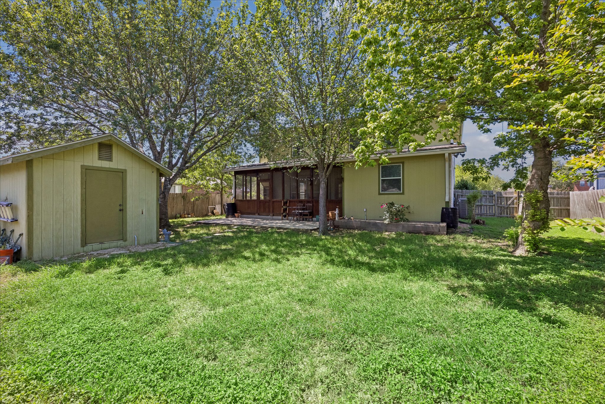 338 Spring Branch Loop Kyle, TX 78640 - Photo 31 of 36 A spacious yard with mature trees and a screened-in porch offers tranquil outdoor living.