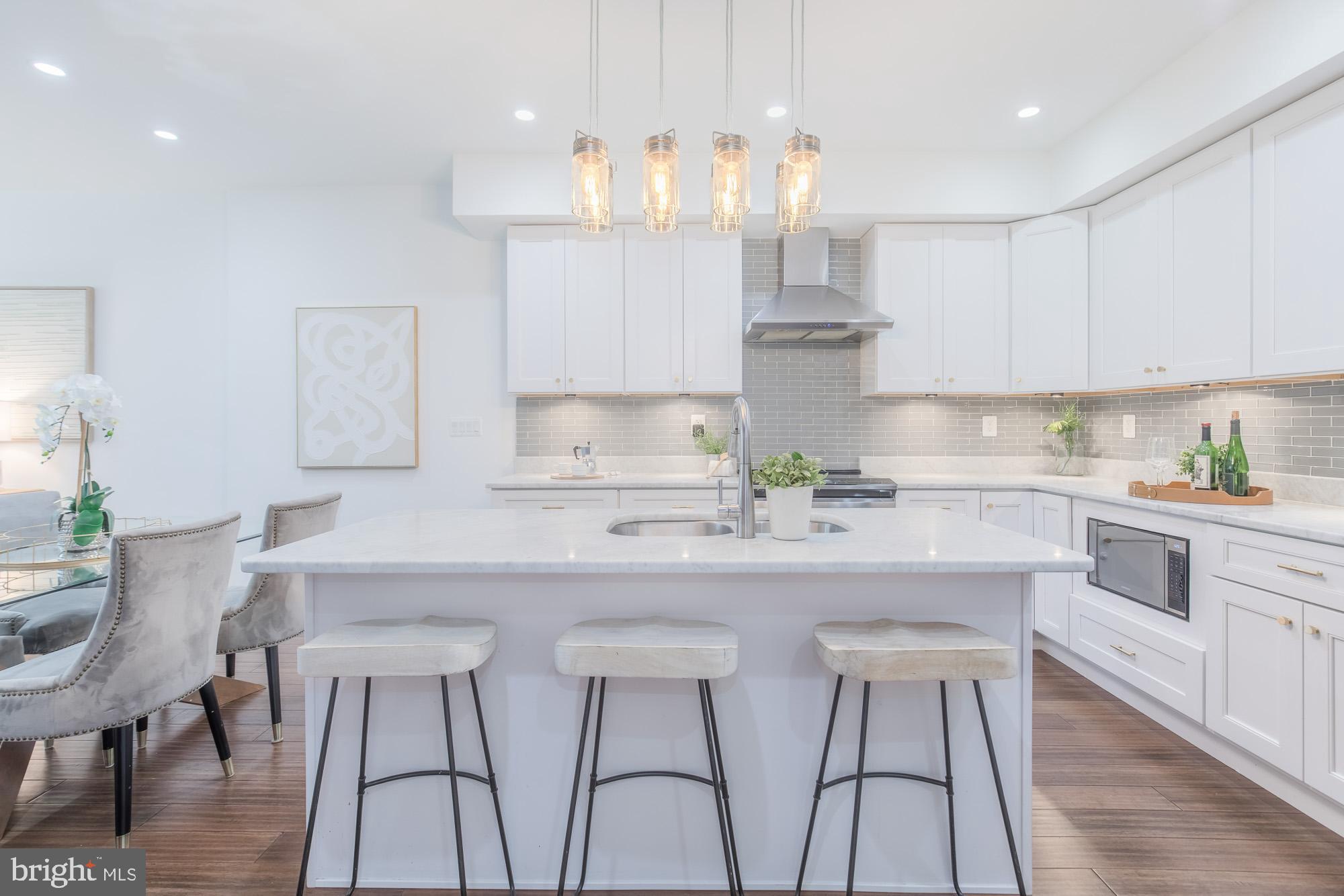 3803 10th Street Northwest, Unit 1 Washington, DC 20011 - Photo 15 of 71 a kitchen with stainless steel appliances granite countertop a white cabinets and chairs