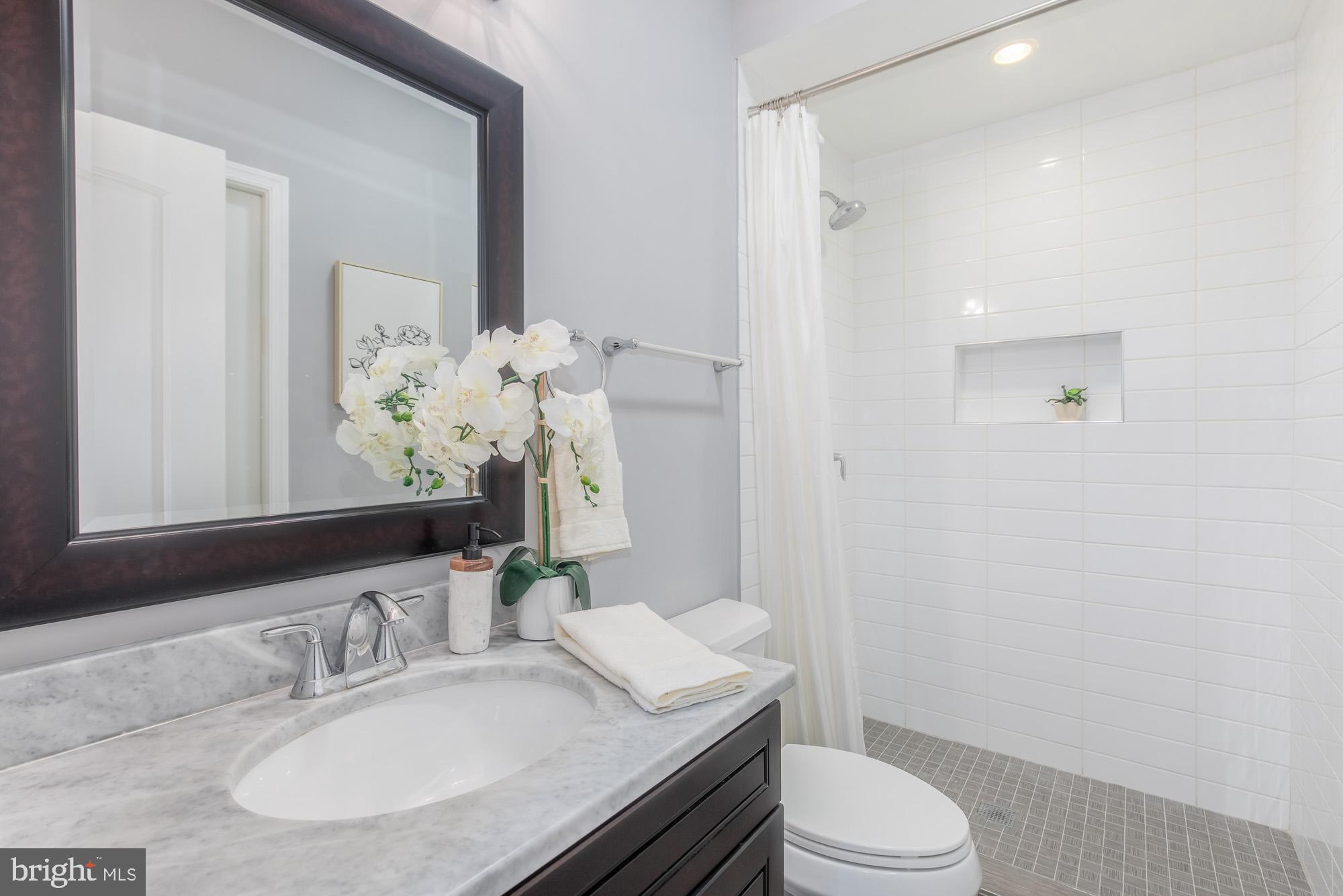 3803 10th Street Northwest, Unit 1 Washington, DC 20011 - Photo 24 of 71 a bathroom with a granite countertop sink toilet a mirror and shower
