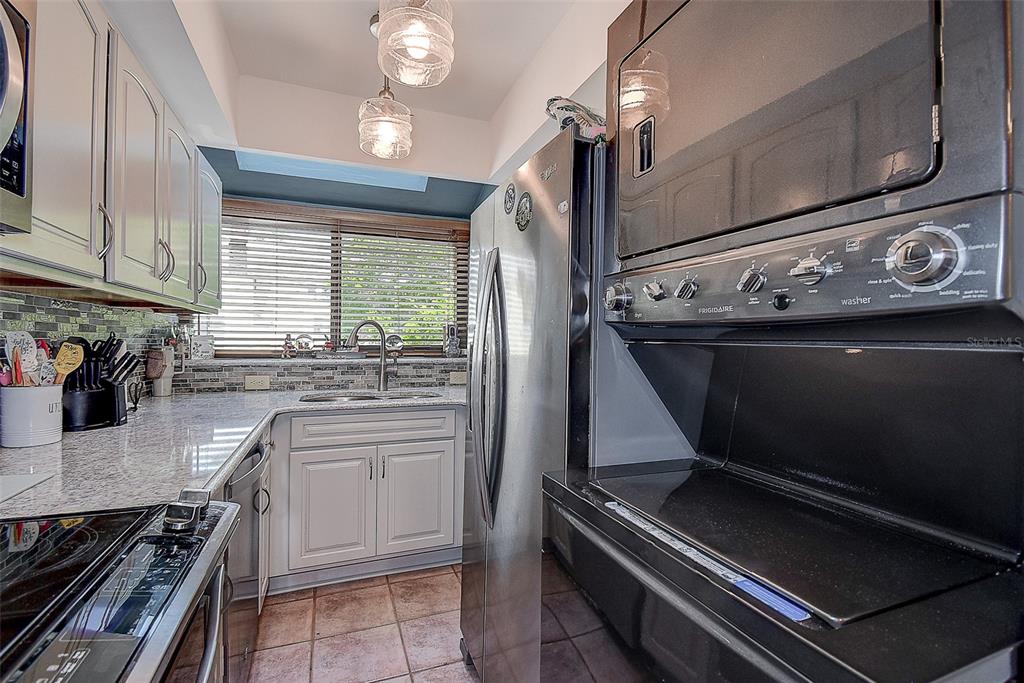 1500 Sunset Road, Unit G4 Tarpon Springs, FL 34689 - Photo 13 of 44 a kitchen with kitchen island granite countertop a stove and a sink