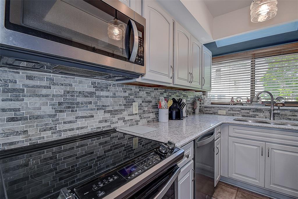 1500 Sunset Road, Unit G4 Tarpon Springs, FL 34689 - Photo 14 of 44 a kitchen with stainless steel appliances granite countertop a sink stove and cabinets