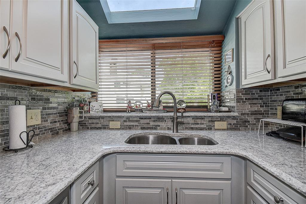 1500 Sunset Road, Unit G4 Tarpon Springs, FL 34689 - Photo 16 of 44 a kitchen with stainless steel appliances granite countertop a sink and a white cabinets