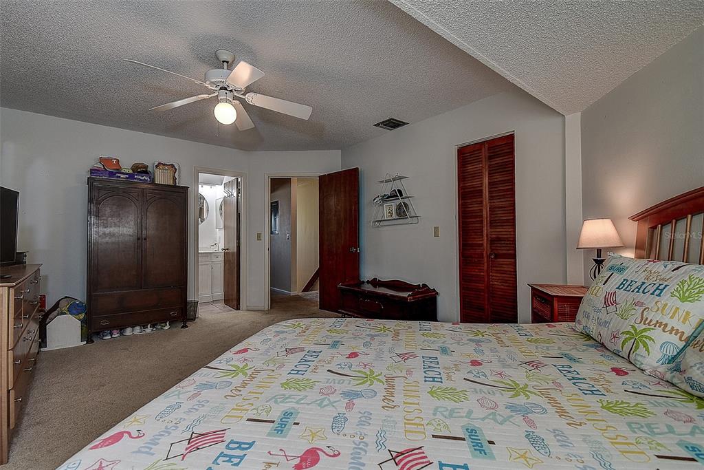 1500 Sunset Road, Unit G4 Tarpon Springs, FL 34689 - Photo 27 of 44 a bedroom with a bed and a chandelier