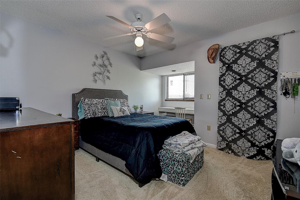 1500 Sunset Road, Unit G4 Tarpon Springs, FL 34689 - Photo 30 of 44 a living room with a large bed and a chandelier