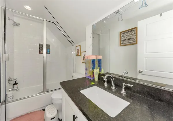 a spacious bathroom with a granite countertop sink and a mirror