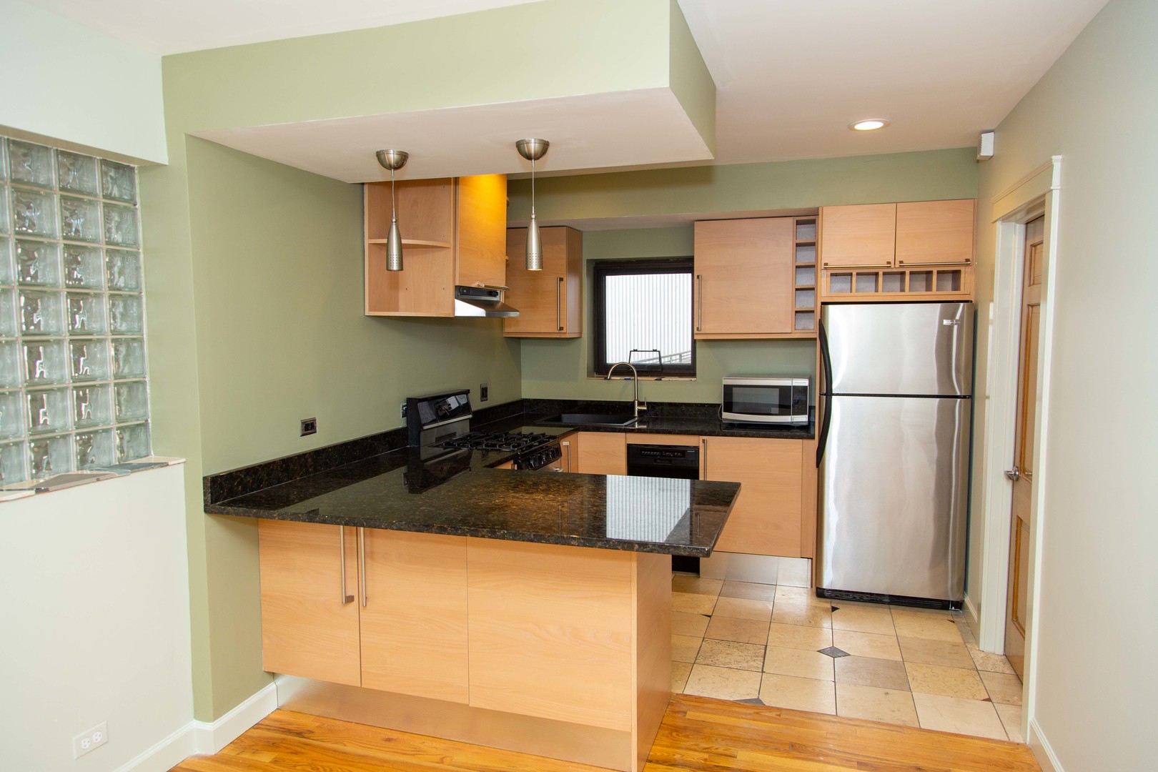 1607 Simpson Street, Unit 2E Evanston, IL 60201 - Photo 12 of 21 a kitchen with granite countertop a sink a stove a refrigerator a washer and dryer