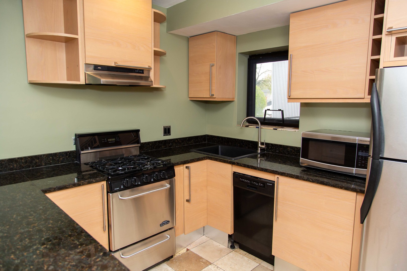 1607 Simpson Street, Unit 2E Evanston, IL 60201 - Photo 13 of 21 a kitchen with stainless steel appliances granite countertop a stove a sink and a microwave