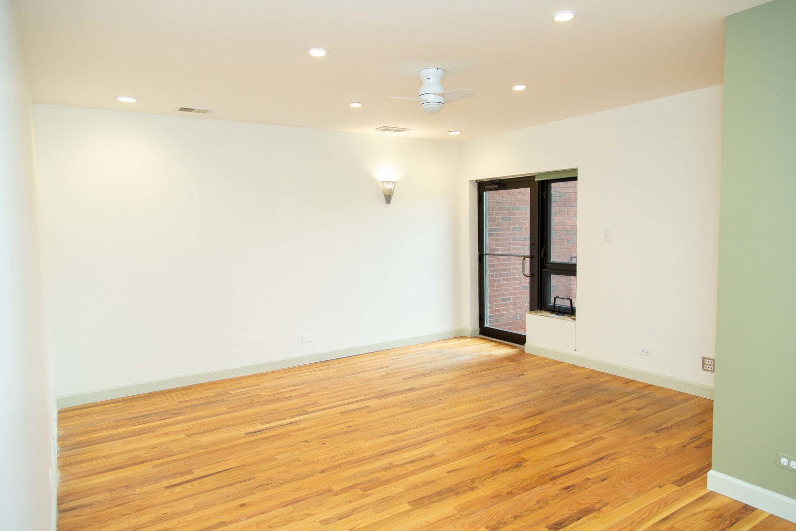 1607 Simpson Street, Unit 2E Evanston, IL 60201 - Photo 4 of 21 a view of an empty room with wooden floor and a window