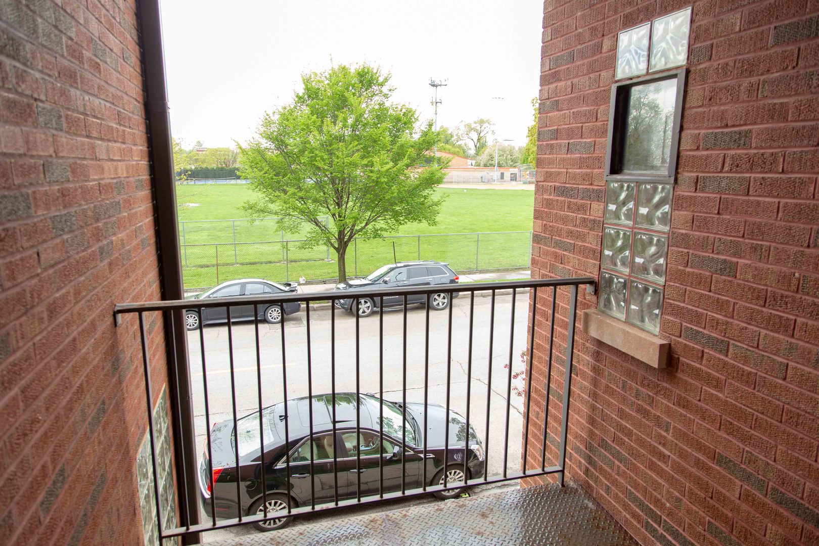 1607 Simpson Street, Unit 2E Evanston, IL 60201 - Photo 6 of 21 a view of a balcony with a floor to ceiling window and wooden fence
