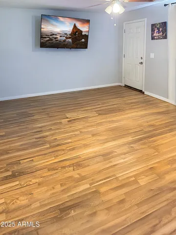 a view of an empty room with wooden floor