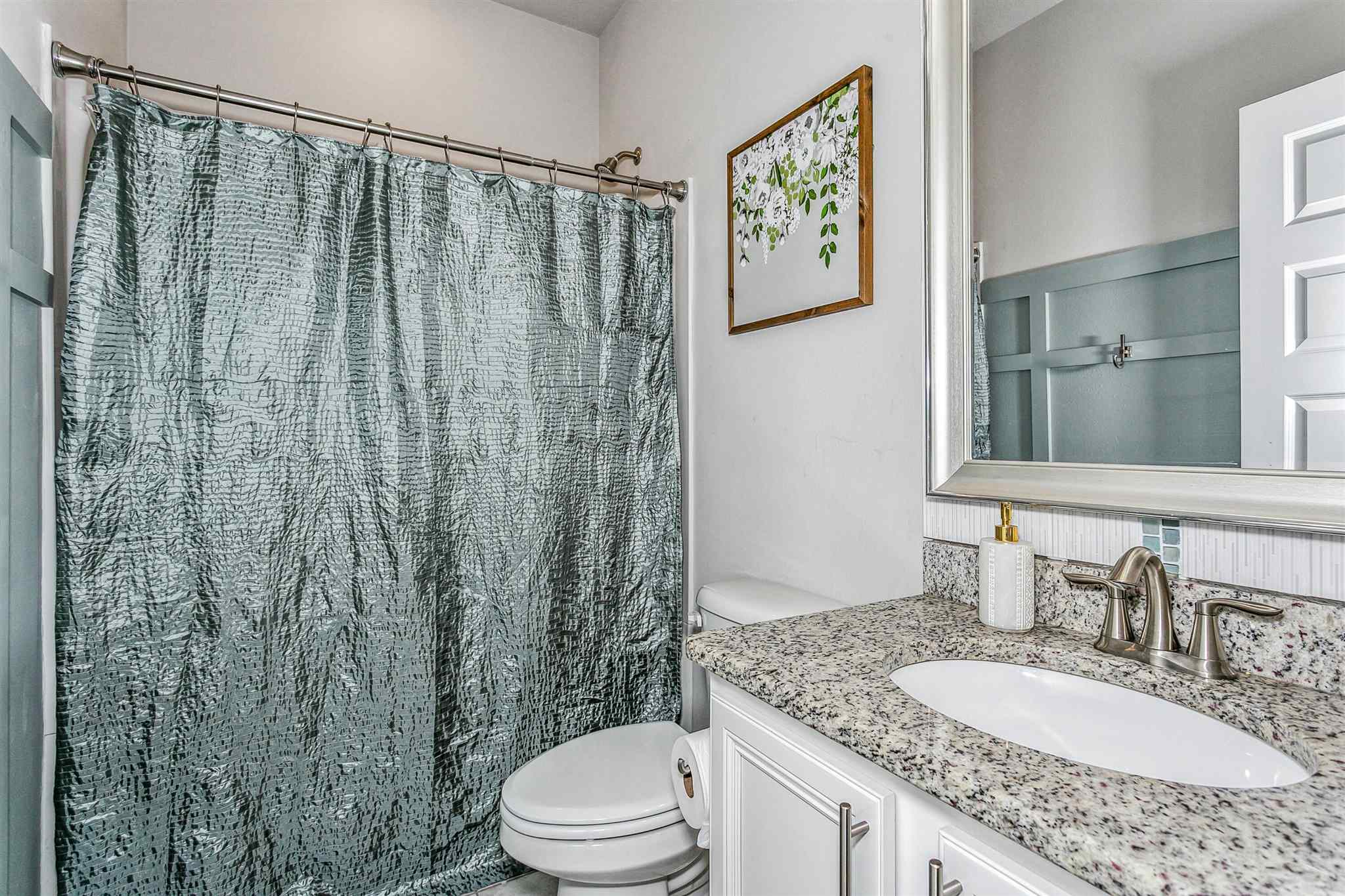 2792 Elkhorn Drive Pace, FL 32571 - Photo 40 of 50 a bathroom with a granite countertop sink a toilet and a mirror