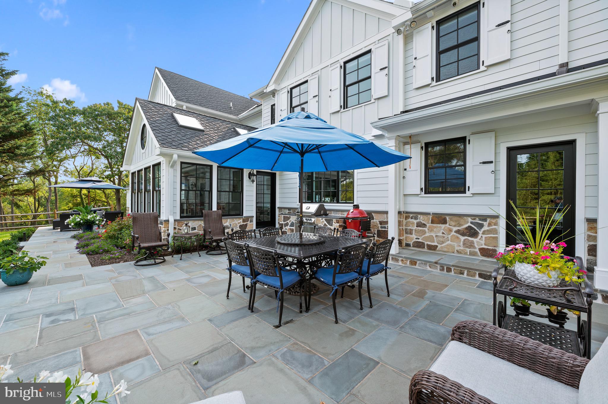 239 Spring Road Malvern, PA 19355 - Photo 7 of 29 a patio with a table and chairs under an umbrella