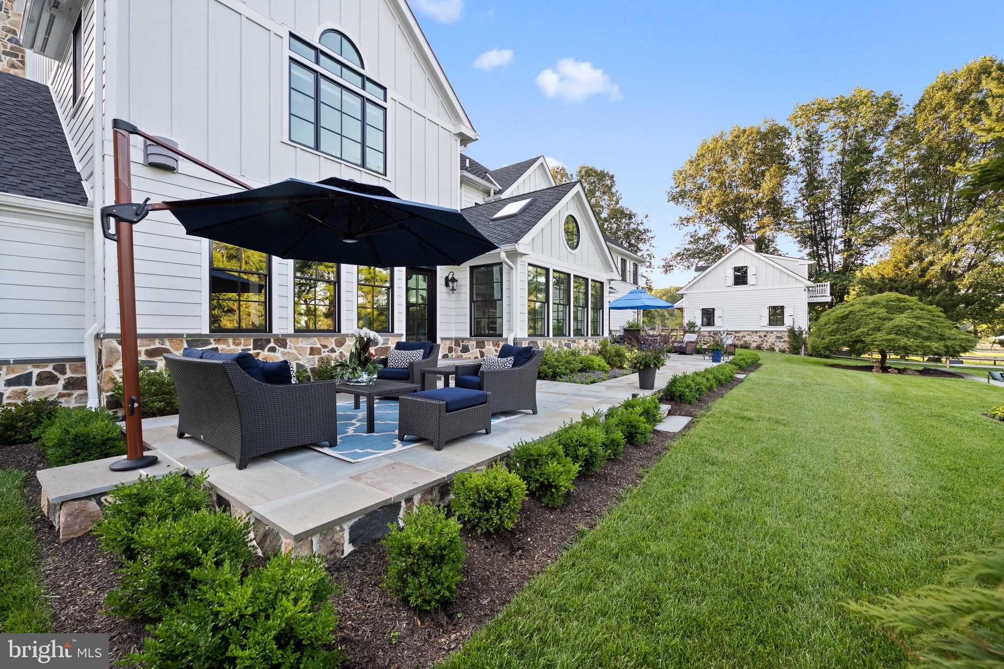 239 Spring Road Malvern, PA 19355 - Photo 9 of 29 a view of a patio with couches table and chairs under an umbrella
