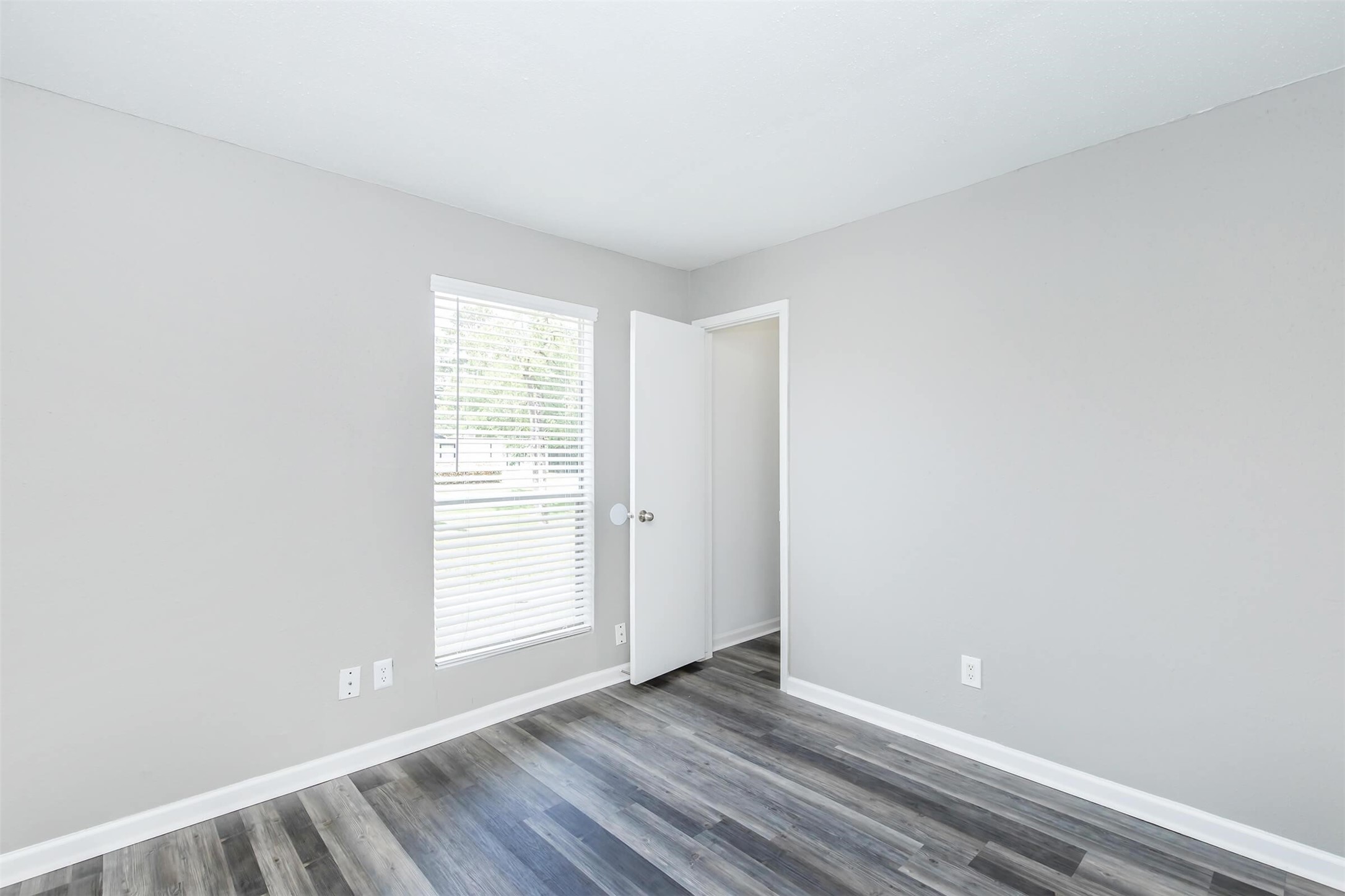 18001 Cypress Trace Road, Unit 504 Houston, TX 77090 - Photo 13 of 34 a view of an empty room with wooden floor and a window