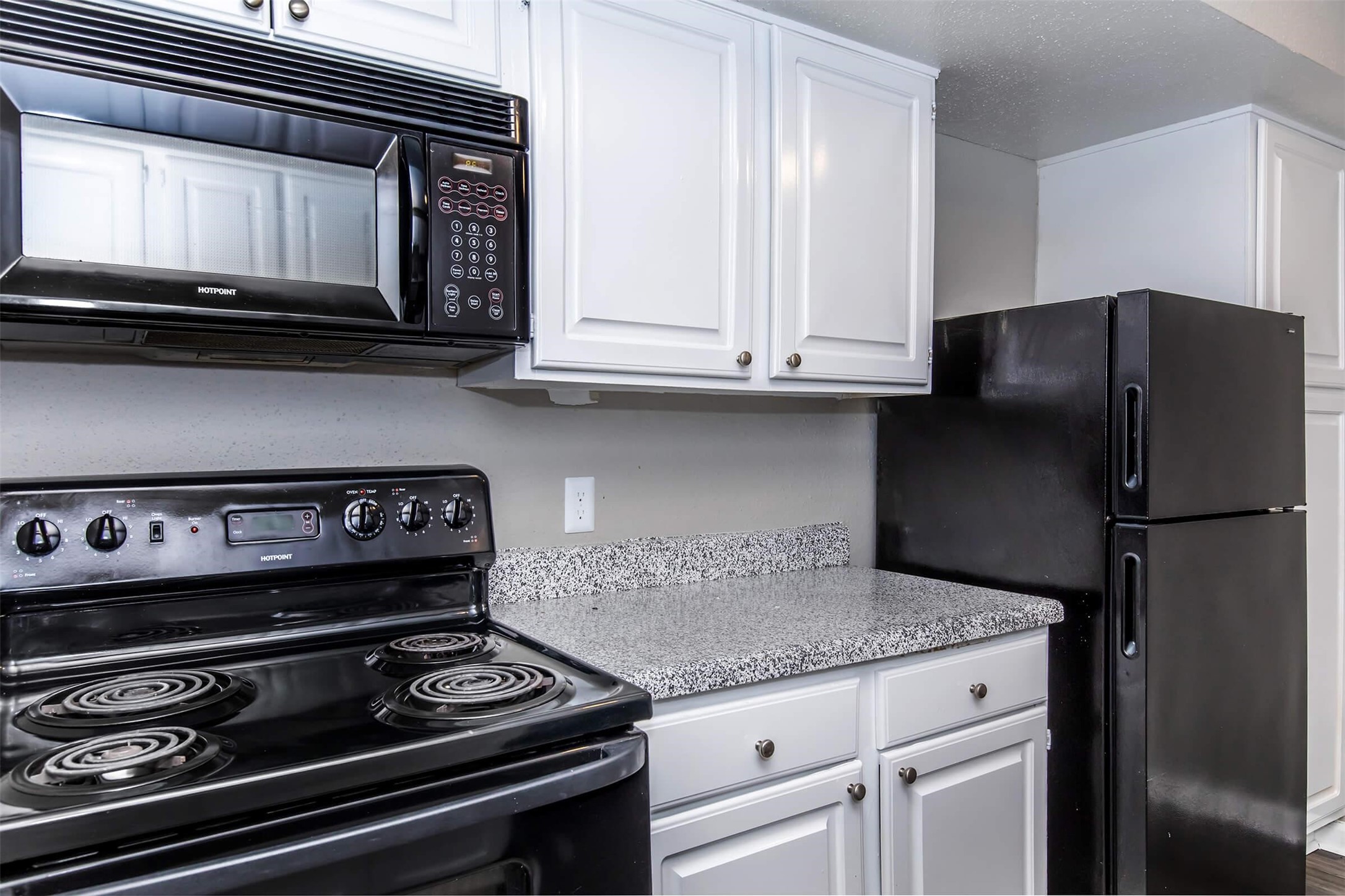 18001 Cypress Trace Road, Unit 504 Houston, TX 77090 - Photo 7 of 34 a kitchen with granite countertop a stove and a microwave