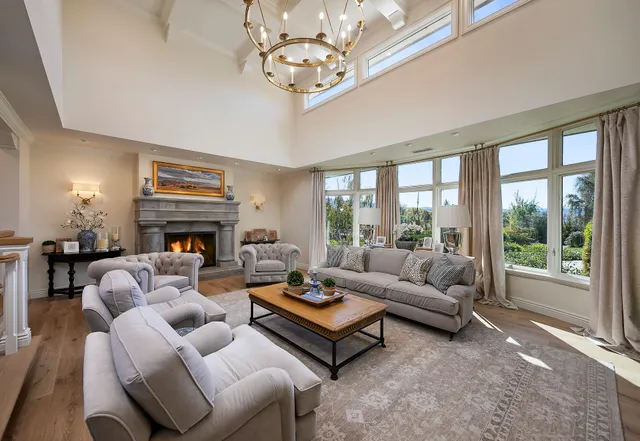 a living room with furniture a fireplace and a large window