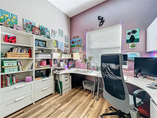 a living room with furniture a ceiling fan and a book shelf