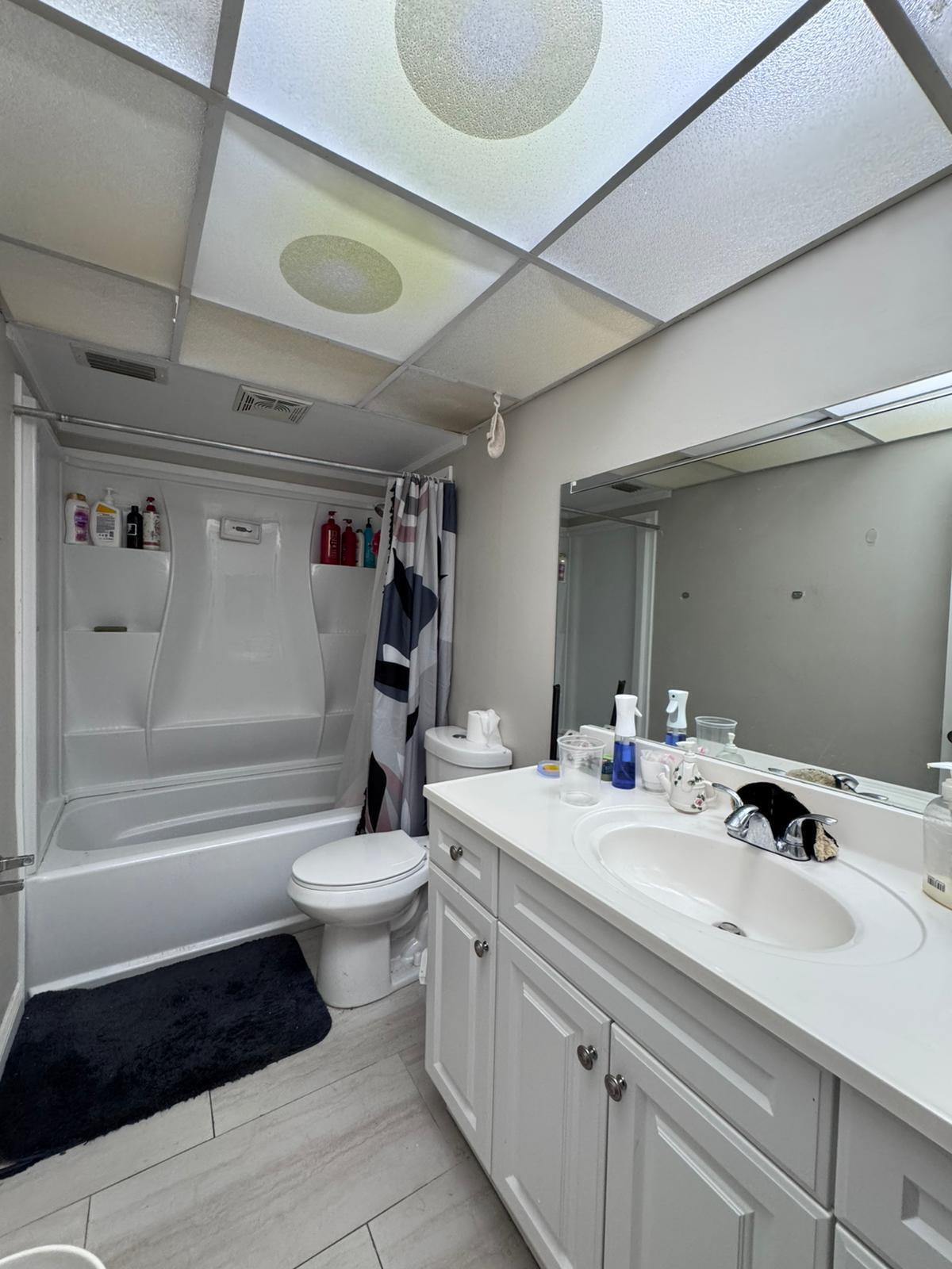 22715 Southwest 66th Avenue, Unit 105 Boca Raton, FL 33428 - Photo 11 of 13 a bathroom with a sink a toilet and shower