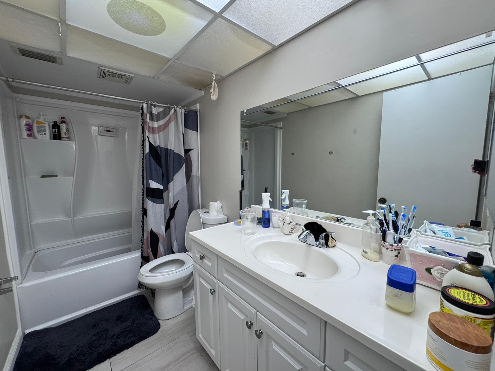 22715 Southwest 66th Avenue, Unit 105 Boca Raton, FL 33428 - Photo 13 of 13 a bathroom with a sink toilet and shower