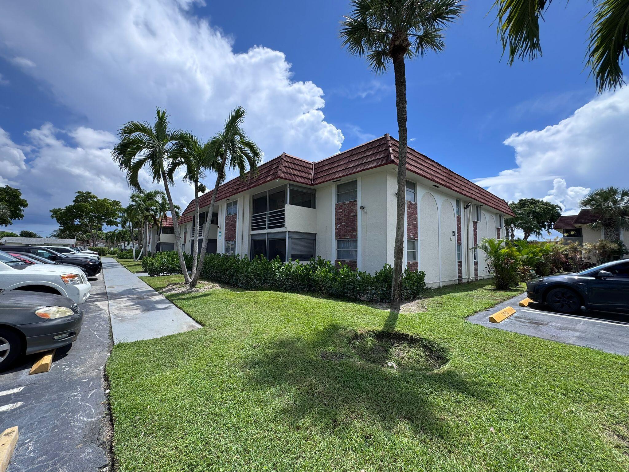 22715 Southwest 66th Avenue, Unit 105 Boca Raton, FL 33428 - Photo 2 of 13 a view of a house with a yard and a yard