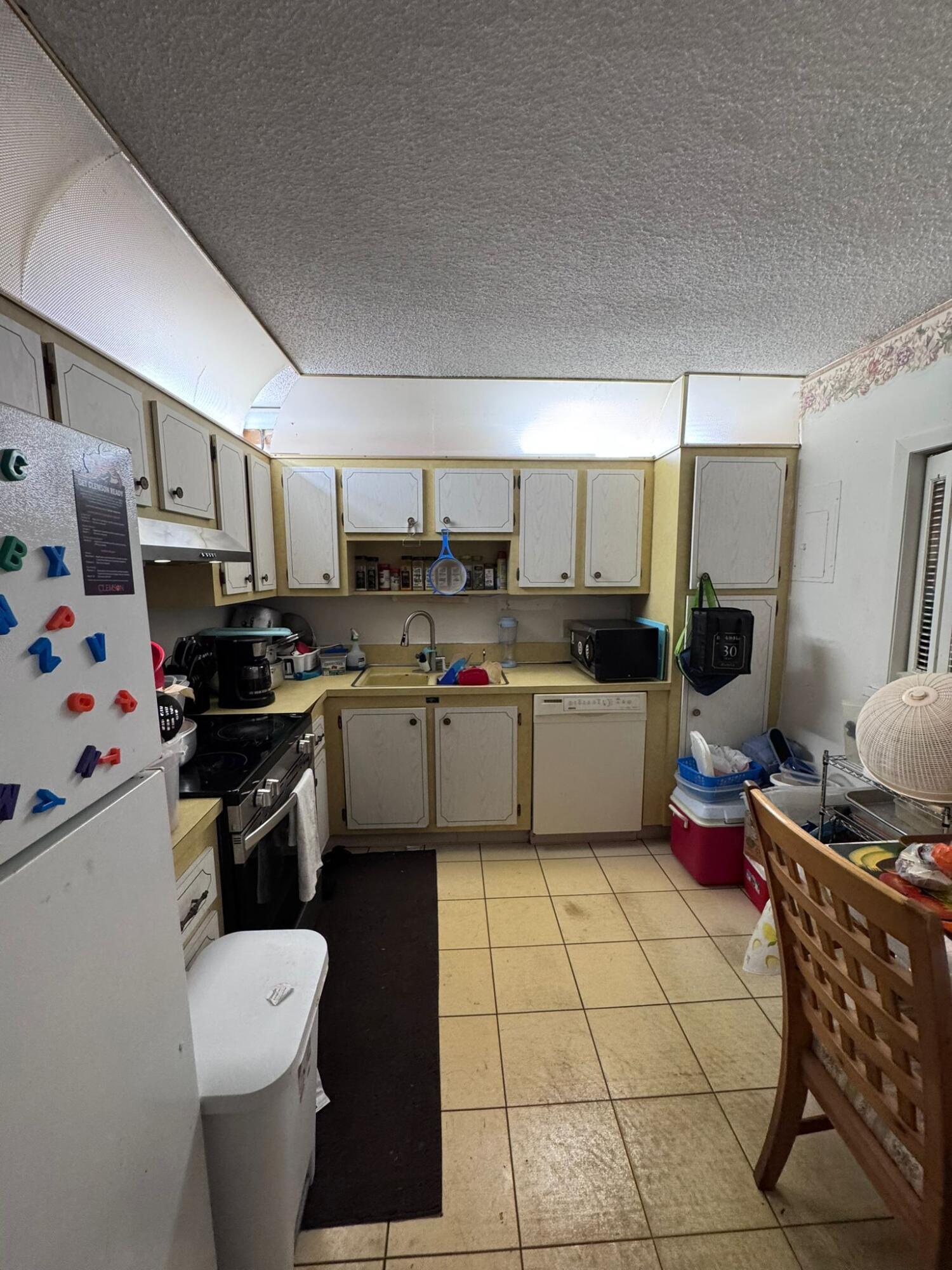 22715 Southwest 66th Avenue, Unit 105 Boca Raton, FL 33428 - Photo 9 of 13 a kitchen with a sink appliances and cabinets