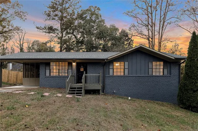 a view of house with backyard and a tree