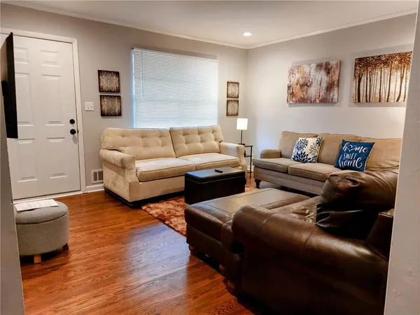 a living room with furniture and a wooden floor