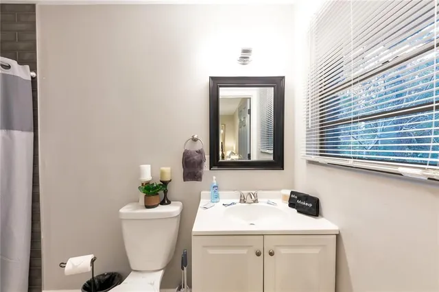 a bathroom with a toilet sink and mirror