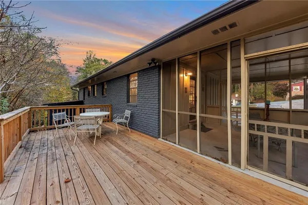 a balcony with wooden floor table and chairs