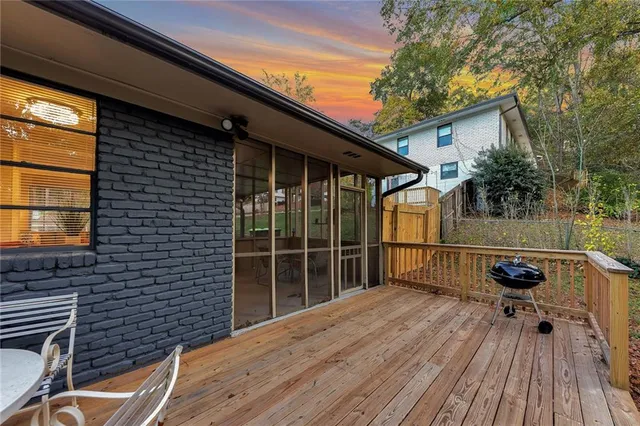a backyard of a house with wooden floor and outdoor seating