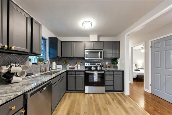 a kitchen with stainless steel appliances granite countertop a sink stove and refrigerator