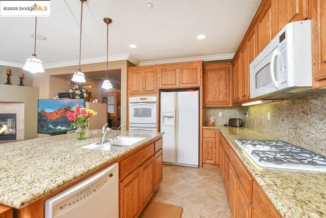 a kitchen with granite countertop a sink stove and refrigerator