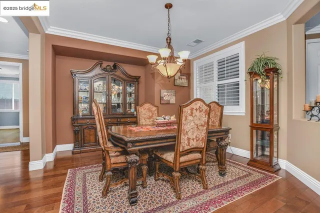 a dining room with furniture a chandelier and wooden floor