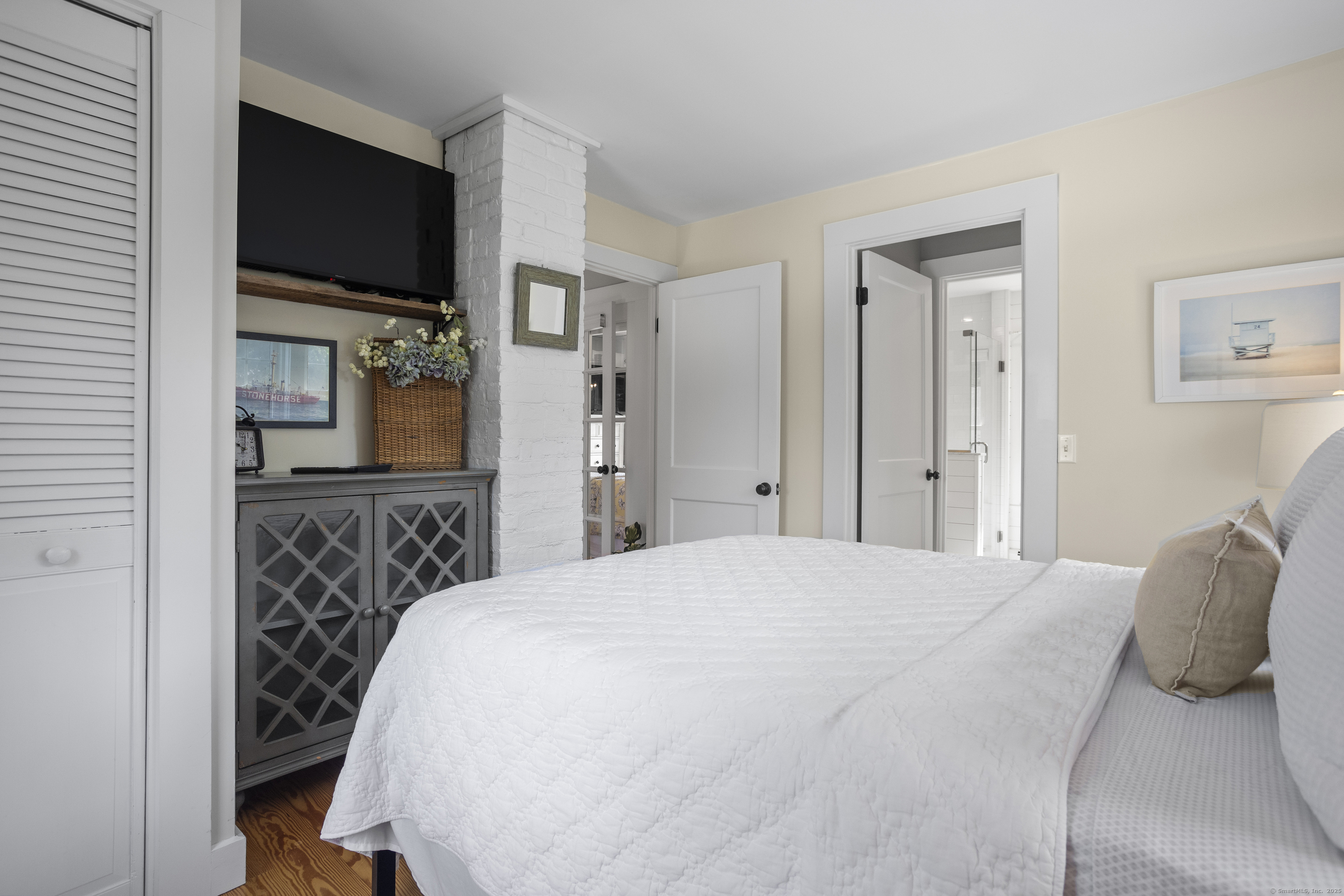 22 School Street Stonington, CT 06355 - Photo 34 of 39 a bedroom with a bed and a flat screen tv