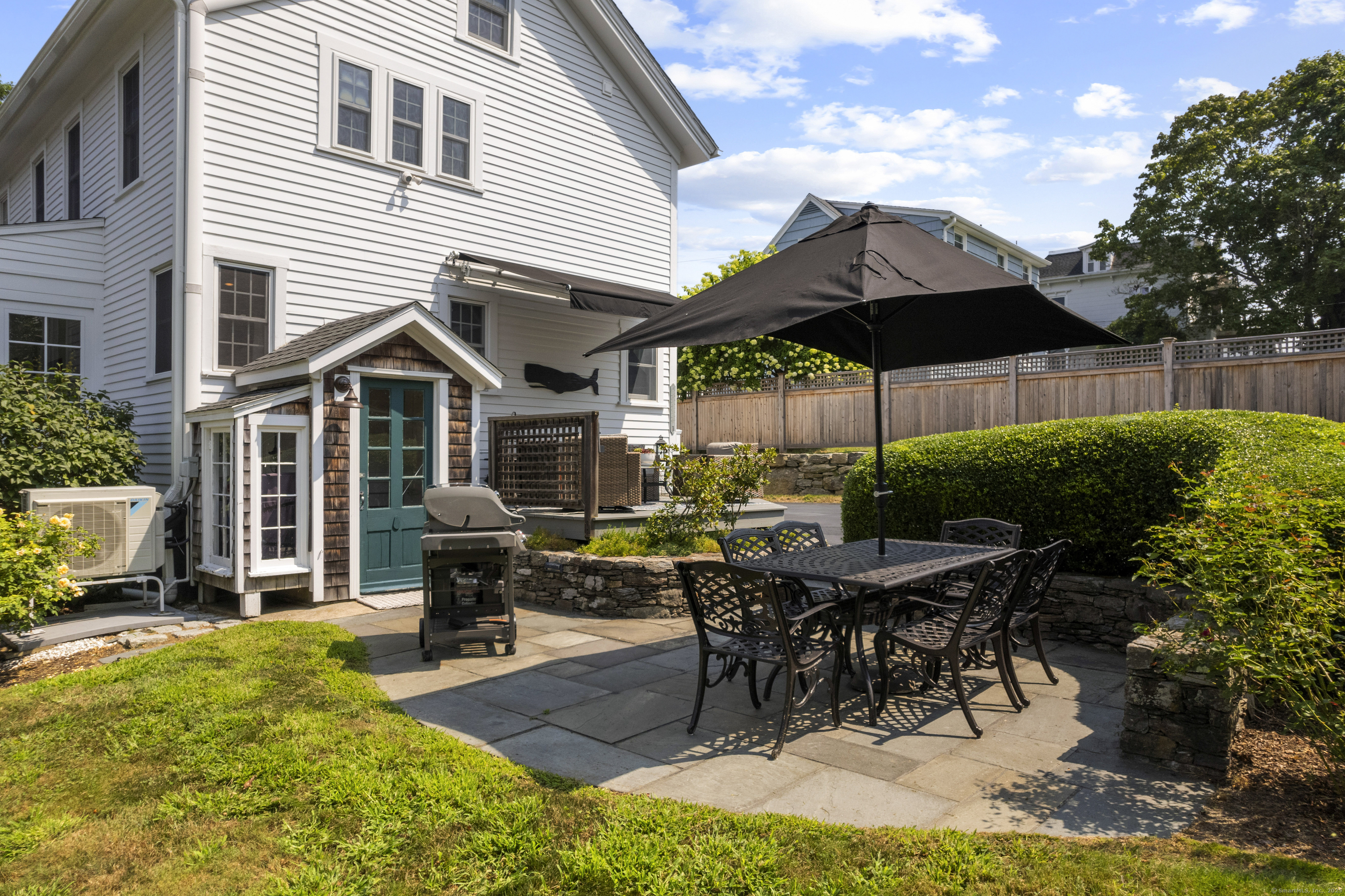 22 School Street Stonington, CT 06355 - Photo 37 of 39 a view of a patio with table and chairs under an umbrella