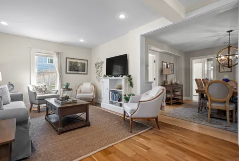 a living room with furniture a flat screen tv and kitchen view