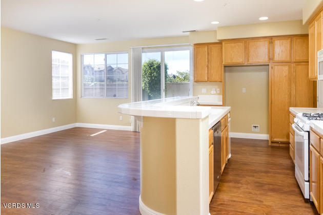 2001 Ribera Drive Oxnard, CA 93030 - Photo 5 of 20 a view of a kitchen with a fridge and wooden floor