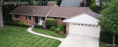 Brick residence with an attached two-car garage, concrete driveway, and a curved paved walkway
