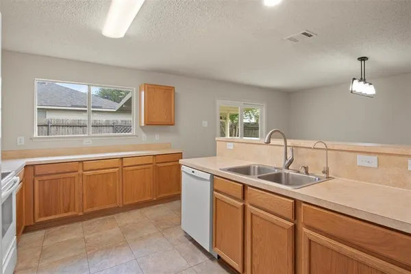 a kitchen with granite countertop a sink and a wooden cabinets