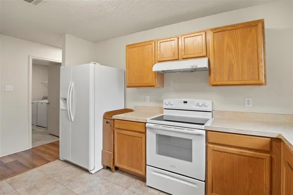 a kitchen with a stove top oven and refrigerator