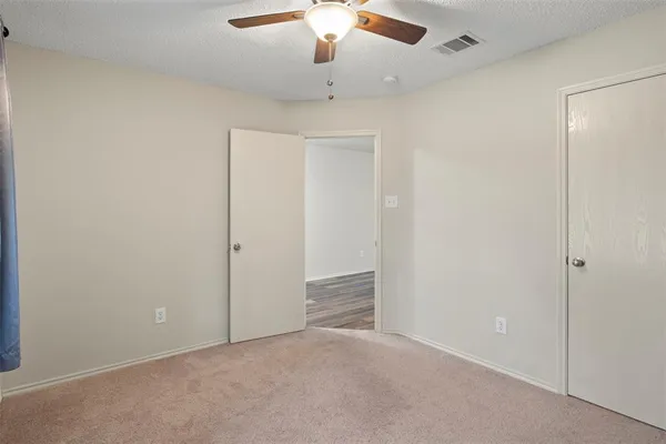 an empty room with chandelier fan