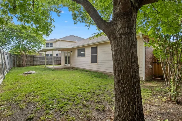 a view of a house with backyard and a tree
