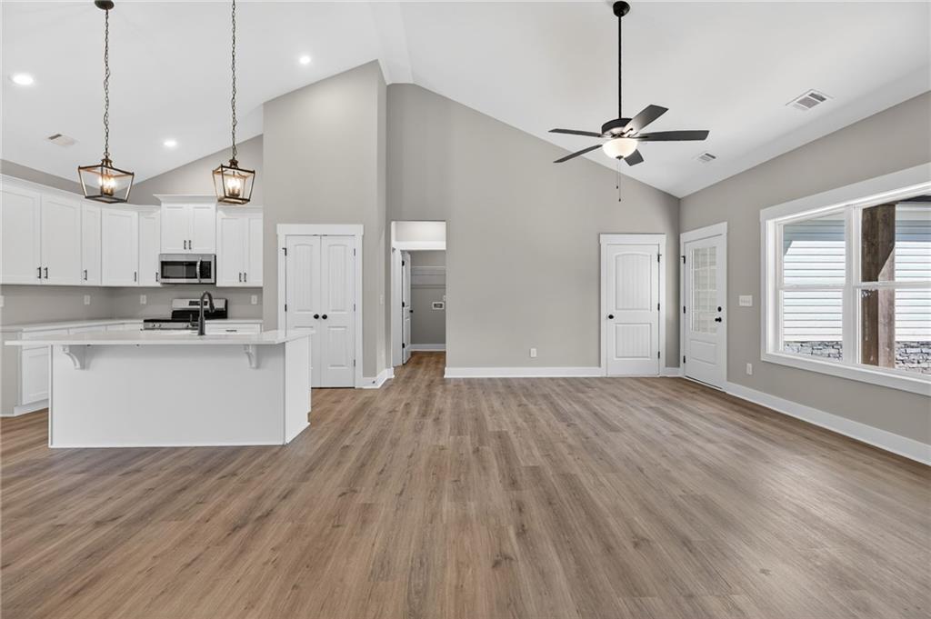 423 Relay Road Silver Creek, GA 30173 - Photo 22 of 48 a view of an empty room and kitchen with wooden floor
