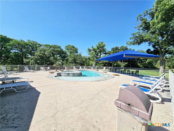 a swimming pool with outdoor seating and yard
